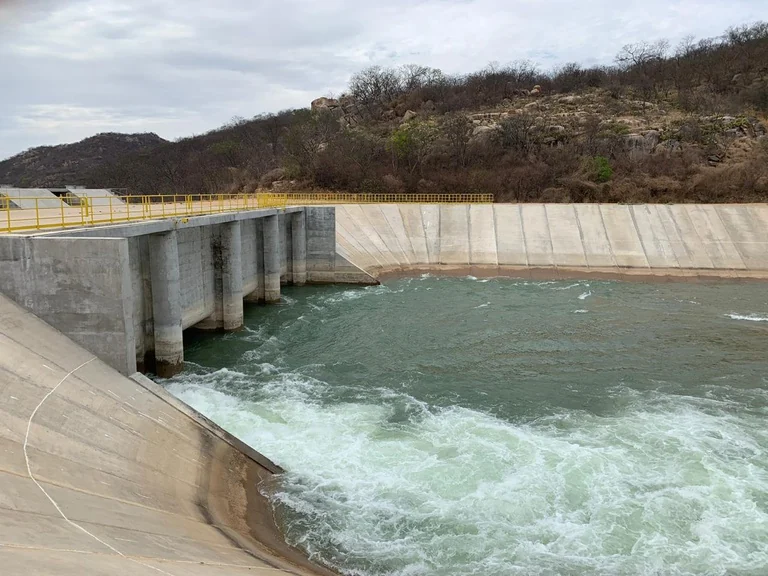 Canal de concreto com água do Projeto de Integração do Rio São Francisco, em meio à vegetação do semiárido.